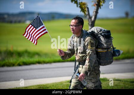 Pyeongtaek, Corée du Sud. 11 septembre 2021. Un soldat de l'armée américaine tire un drapeau américain alors qu'il termine une marche de 9.11 miles lors d'un événement en mémoire à l'occasion du 20e anniversaire des attaques terroristes de 9/11 au Camp Humphreys le 11 septembre 2021 à Pyeongtaek, en Corée du Sud. L'événement commémore les près de 3,000 personnes tuées par des terroristes le 11 septembre 2001. Crédit: SPC. Matthew Marcellus/États-Unis Armée/Alamy Live News Banque D'Images