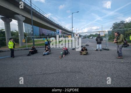 Londres, Royaume-Uni. 21 septembre 2021. Les gens sont assis devant les portes est d'Excel où commence la foire internationale des armes de défense et de sécurité de l'équipement de la semaine prochaine. DSEI est la plus grande foire aux armes au monde et les entreprises vendront des bombes et d'autres armes aux délégations militaires des zones de conflit et des régimes répressifs avec la bénédiction du gouvernement britannique. Peter Marshall/Alay Live News Banque D'Images