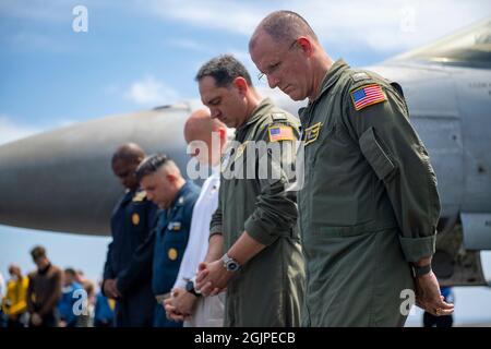 USS Carl Vinson, États-Unis. 11 septembre 2021. La Marine américaine Carl Vinson Carrier Strike Group fait une pause pour un moment de silence lors d'un événement commémorant le 20e anniversaire des attaques terroristes de 9/11 à bord du porte-avions USS Carl Vinson le 11 septembre 2021 en mer de Chine méridionale. L'événement commémore les près de 3,000 personnes tuées par des terroristes le 11 septembre 2001. Crédit : MCS Megan Alexander/États-Unis Navy/Alamy Live News Banque D'Images