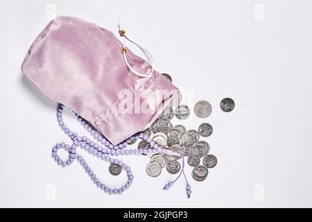 Concept de la finance islamique sur fond blanc. Finance conforme à la charia - activité bancaire ou financière. Pièces de monnaie et perles de prière. Zakat, islamique Banque D'Images