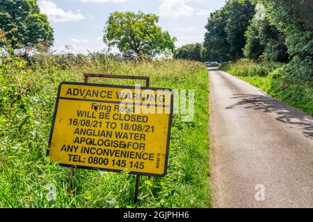 Un panneau sur une voie de campagne de Norfolk avertit de la fermeture de la route pour les travaux principaux d'eau. Banque D'Images