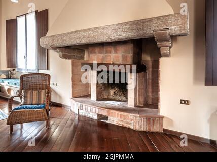 Cheminée rustique en briques avec poutres en bois anciennes à l'intérieur de la maison, concept de décoration intérieure. Banque D'Images