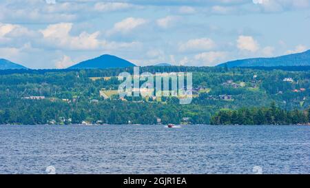 Ville de Rangeley, Maine, vue depuis le parc d'État de Rangeley Lake. Maisons sur une colline. Des sommets de montagne élevés à l'arrière. Un hors-bord sur le lac Rangeley Banque D'Images