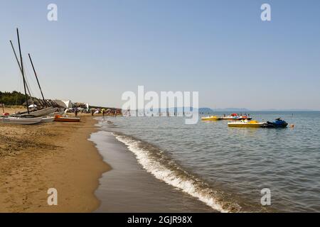 Vue sur la plage de sable sur la côte de la Maremme toscane avec des voiliers et des bateaux à pédales en été sur la rive de la mer, Marina di Castagneto Carducci Banque D'Images