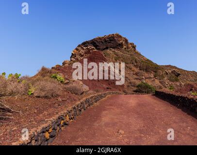 Chemin vers le volcan Monte Nero de Linosa. Route de campagne caractéristique avec le mur de pierre sèche construit avec des pierres de lave Banque D'Images