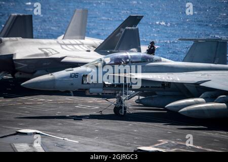 210911-N-YN807-2040 MER DE CHINE DU SUD (SEPT 11, 2021) Un Sailor nettoie un Super Hornet F/A-18F, affecté aux chasseurs Bounty du Strike Fighter Squadron (VFA) 2, sur le pont de vol à bord du porte-avions de la classe Nimitz USS Carl Vinson (CVN 70), le 11 septembre 2021. Carl Vinson Carrier Strike Group est en cours de déploiement prévu dans la zone d'exploitation de la 7e flotte des États-Unis afin d'améliorer l'interopérabilité par le biais d'alliances et de partenariats tout en servant de force d'intervention prête à l'emploi pour soutenir une région Indo-Pacifique libre et ouverte. (É.-U. Photo marine par le Matelot de 1re classe Megan Alexander) Banque D'Images