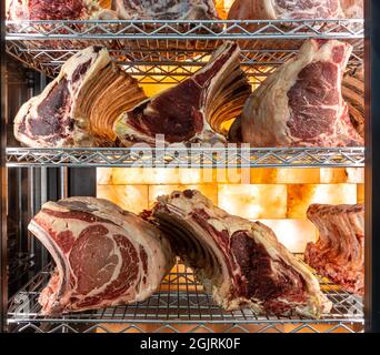 Steak de bœuf dans une armoire de vieillissement de viande séchée. Grillades au réfrigérateur dans un délicieux restaurant gastronomique. Sécher la viande vieillissante en chambre froide. Coupe séchée