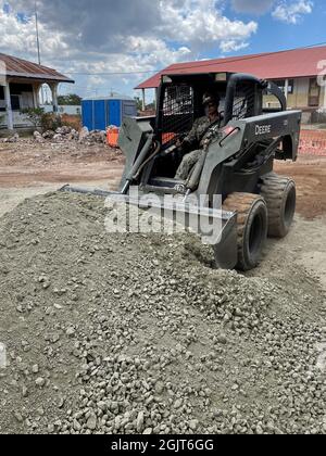 210901-N-RP125-1003 BAUCAU (Timor-Leste) (1er septembre 2021) opérateur d'équipement de deuxième classe Eddie Otriz, affecté au bataillon de construction mobile navale (NMCB) 5, exploite une mini-chargeuse pour répartir le gravier et niveler le sol. Les Seabees de la Marine américaine avec le NMCB-5 construisent l'école pour soutenir le ministère local de l'éducation. Le NMCB-5 est déployé dans la zone d'opérations de la 7e flotte américaine, soutenant une Indo-Pacifique libre et ouverte, renforçant un réseau d'alliés et de partenaires, et fournissant un soutien général en génie et en civil aux forces opérationnelles conjointes. Homeporté de Port Hueneme, Califo Banque D'Images