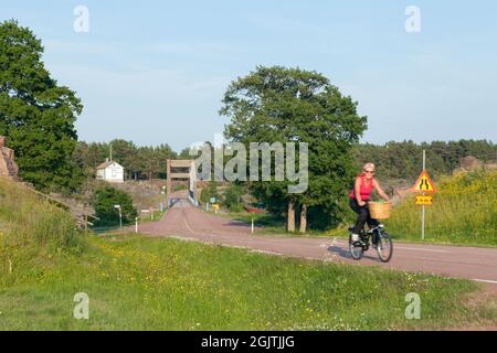 BOMARSUND, ALAND, LE 26 JUIN 2013. Vue sur un pont et une route au muséon extérieur. Femme non identifiée sur un cycle. Éditorial Banque D'Images