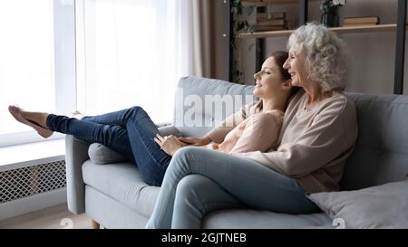 Une famille souriante et solidaire de deux générations appréciant un week-end paisible à la maison. Banque D'Images