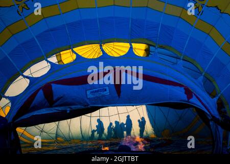 Reno, États-Unis. 11 septembre 2021. Des gens silhouetés par le soleil lors d'une course de montgolfière. La Great Reno Balloon Race annonce son auto-portrait comme la plus grande course gratuite de montgolfière au monde. Elle célèbre son 40e anniversaire cette année. Crédit : SOPA Images Limited/Alamy Live News Banque D'Images