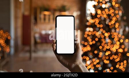 Gros plan de l'homme biracial tenir le téléphone cellulaire avec écran blanc Banque D'Images