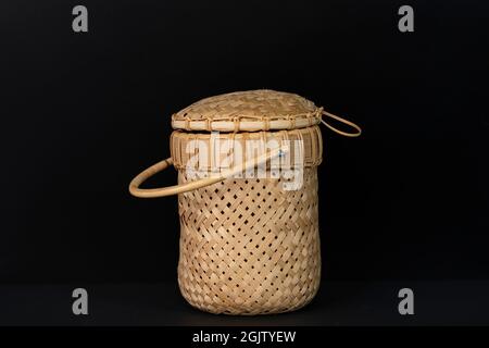 Un beau récipient avec couvercle en feuilles de PIN sur fond noir. Banque D'Images