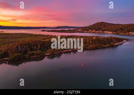 Paysage aquatique coloré au coucher du soleil avec des bateaux à Woy Woy, Nouvelle-Galles du Sud, Australie. Banque D'Images