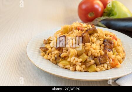 Pilaf turc traditionnel de bulgur, légumes et aubergines sur la table dans une assiette Banque D'Images