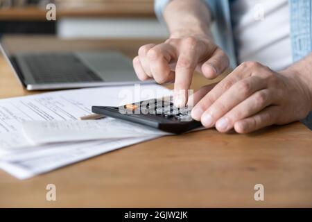 L'homme coûte des revenus et des dépenses personnels à l'aide de la calculatrice gros plan Banque D'Images