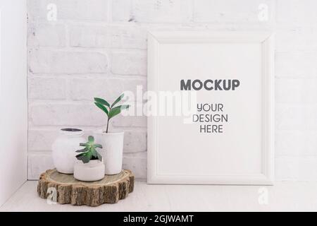 Image vide maquette avec cadre en bois sur fond de mur de brique blanche avec plantes succulentes sur une coupe en bois. Intérieur clair Banque D'Images