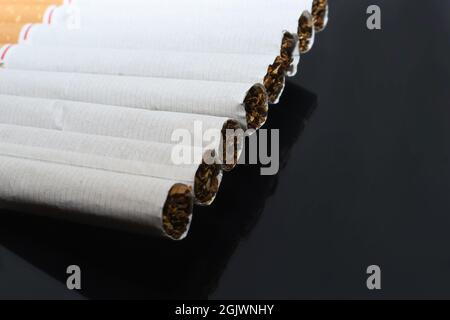 cigarettes avec filtre blanc sur fond sombre. Banque D'Images
