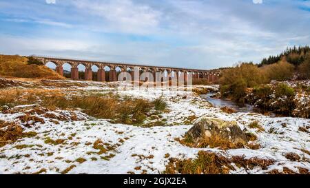 La grande eau de la flotte entourée de neige en hiver, avec le viaduc de chemin de fer en arrière-plan, Dumfries et Galloway, Écosse Banque D'Images