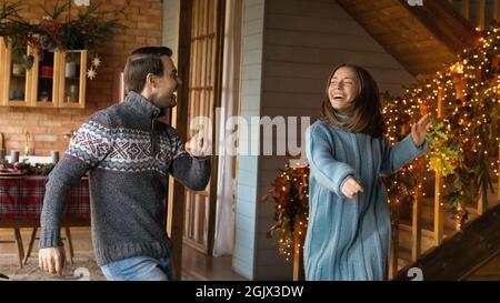 Joyeux couple familial millénaire actif s'amusant à l'intérieur. Banque D'Images