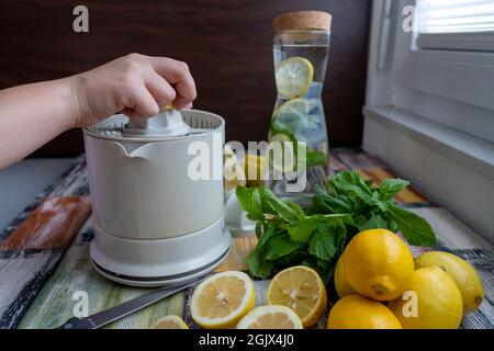 Préparation de jus frais presser sur citron frais et citron vert. Presse-citron ou presse-citron. Banque D'Images