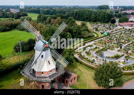 12 septembre 2021, Basse-Saxe, Barßel : le moulin à vent Ebkenssche Windmühle, une galerie de trois étages de 1892, se dresse dans le village ensoleillé en face du cimetière (vue aérienne avec drone). En plus des châteaux et des musées de Basse-Saxe, de nombreux moulins à vent historiques ouvrent également leurs portes aux visiteurs lors de l'Open Monument Day. Photo: Hauke-Christian Dittrich/dpa Banque D'Images