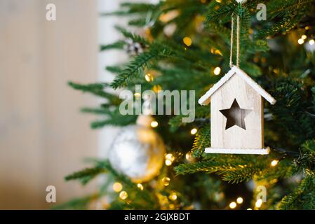 L'arbre est décoré avec une boule d'argent et une maison en bois de jouet sur un fond flou, étincelant et fabuleux or avec beau bokeh, espace copie, Banque D'Images