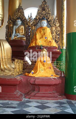 TEMPLE, MYANMAR (BIRMANIE) - 25 août 2021 : un cliché vertical de statues de Bouddha doré sur l'autel bouddhiste à l'intérieur d'un temple Banque D'Images