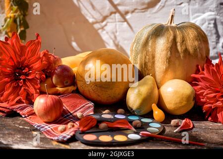 Automne coloré esthétique encore vie: Fruits jaunes, légumes et peintures vives avec un pinceau, potiron, poires, pomme et melon. Jour de Thanksgiving. AUT Banque D'Images