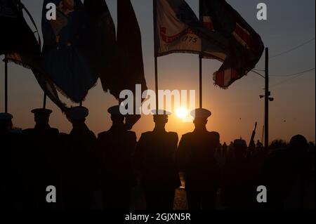 Cape May, États-Unis. 11 septembre 2021. La Garde côtière américaine recrute une équipe d'exercices cérémoniels et un garde de couleurs sont silhouetés par le soleil couchant lors d'une commémoration du 20e anniversaire des attaques terroristes de 9/11 au Centre d'entraînement de la Garde côtière le 11 septembre 2021 à Cape May, dans le New Jersey. L'événement commémore les près de 3,000 personnes tuées par des terroristes le 11 septembre 2001. Crédit : Matelot de 1re classe Christian Lower/U.S. Coast Guard/Alamy Live News Banque D'Images