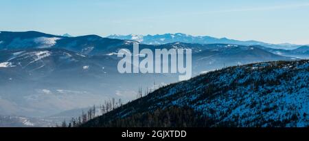 Les collines les plus proches des montagnes de Beskid Zywiecki et les sommets des montagnes de Tatra en arrière-plan du sentier de randonnée situé sous la colline de Magurka Wislaska en hiver BES Banque D'Images