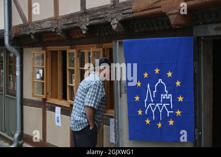 Quedlinburg, Allemagne. 12 septembre 2021. Un homme regarde dans une fenêtre d'une maison à colombages. Dans la région de Harz, de nombreuses maisons classées ont ouvert leurs portes au public lors du week-end du jour du Monument ouvert. Credit: Matthias Bein/dpa-Zentralbild/ZB/dpa/Alay Live News Banque D'Images