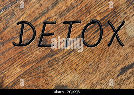 Detox, mot en lettres majuscules manuscrites noires sur fond de texture bois Banque D'Images
