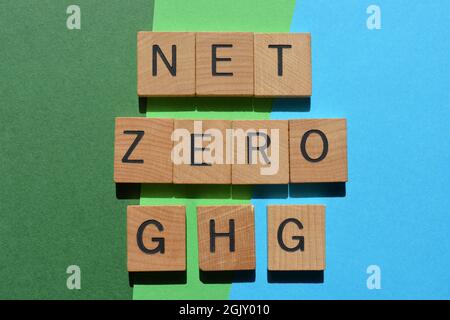 Net Zero GHG, mots en lettres de l'alphabet en bois isolés sur fond bleu et vert Banque D'Images