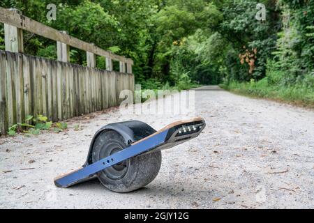 Skateboard électrique à une roue (transporteur personnel) sur une piste de vélo en gravier Banque D'Images