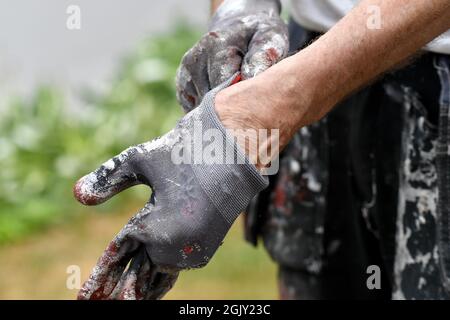 Un homme portant des gants de protection pour la peinture Banque D'Images