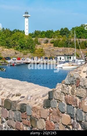 Vastervik, Suède - 08.22.2021: Mince bâtiment blanc de phare avec baie en face lors d'une belle journée d'été. Banque D'Images