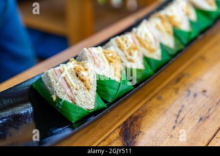 Gros plan sur les sandwichs de porc déchiquetés séchés disposés sur un plat de bateau noir. Banque D'Images