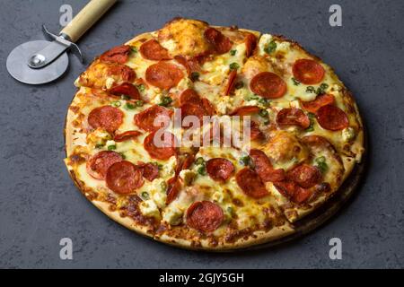 Savoureuse pizza pepperoni faite avec du salami, feta, poivrons chiliens sur fond de béton noir. Vue de dessus de pizza chaude au pepperoni. Avec espace de copie pour le texte. Banque D'Images
