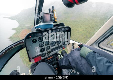 Vietas, Suède - 08.16.2021: Panneau de commande dans un cockpit de petit hélicoptère avec façade et fond en verre survolant un paysage arctique difficile sur un très Banque D'Images