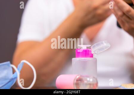 La photo en gros plan d'une lotion cosmétique dans la bouteille rose, le spray et le masque médical sur la table pour enlever l'acné après apparés après avoir utilisé le visage Banque D'Images