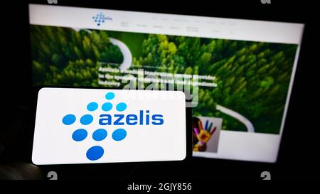 Personne tenant un smartphone avec le logo de la société chimique belge Azelis Holding S.A. sur écran devant le site. Mise au point sur l'affichage du téléphone. Banque D'Images