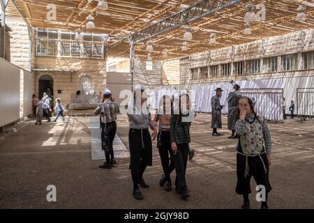 Jeunes Juifs orthodoxes de la secte antisioniste Toldos Aharon dans la cour de leur yeshiva dans le quartier religieux de MEA Shearim. Jérusalem Ouest Israël Banque D'Images