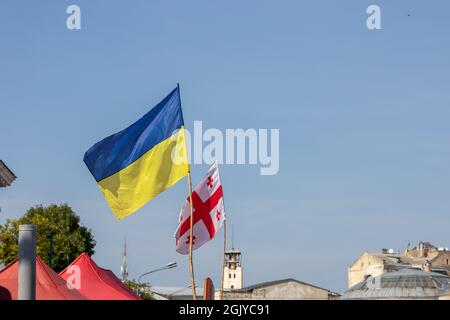 les drapeaux de l'ukraine et de la géorgie flottent sur fond de ciel dégagé Banque D'Images