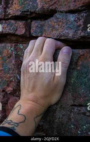 Gros plan de la main crayeuse d'un grimpeur sur une petite fissure sur une roche. Banque D'Images