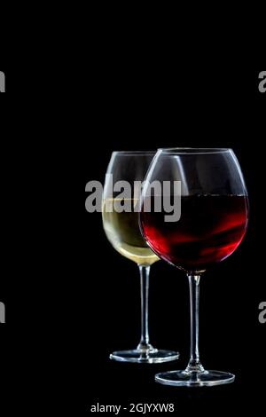 Deux verres de vin rouge et blanc sur fond noir. Banque D'Images