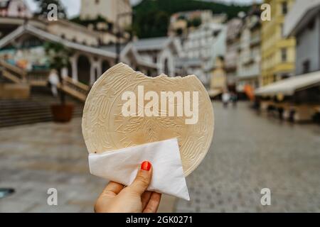 Célèbre cachets de Carlsbad, CZ: Lazenske oplatky, originaire de 1867. Femme tenant main de la traditionnelle tchèque biscuit doux en-cas fait à Karlovy Vary, célèbre s. Banque D'Images