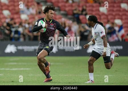 SINGAPOUR-AVRIL 14 : Ryan Olofofela de l'équipe d'Angleterre 7s (bleu) en action contre l'équipe de Carlin Isles des États-Unis 7s (blanc) lors du match de médaille de bronze de HSBC World Rugby Singapore Sevens le 14 avril 2019 au Stade national de Singapour Banque D'Images