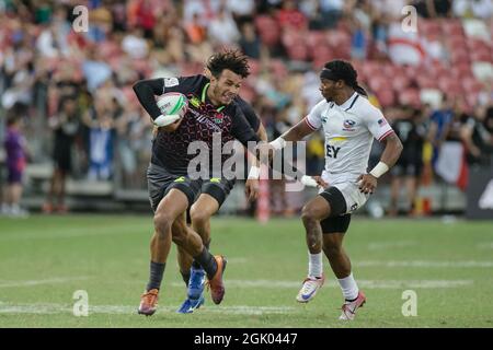 SINGAPOUR-AVRIL 14 : Ryan Olofofela de l'équipe d'Angleterre 7s (bleu) en action contre l'équipe de Carlin Isles des États-Unis 7s (blanc) lors du match de médaille de bronze de HSBC World Rugby Singapore Sevens le 14 avril 2019 au Stade national de Singapour Banque D'Images