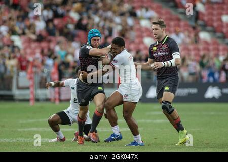 SINGAPOUR-AVRIL 14:l'équipe d'Angleterre 7s (bleue) joue contre l'équipe d'USA 7s (blanche) lors du match de médaille de bronze de HSBC World Rugby Singapore Sevens le 14 avril 2019 au Stade national de Singapour Banque D'Images